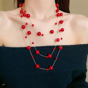 Elegant multi-layered vintage red round faux pearl necklace shown on a female model