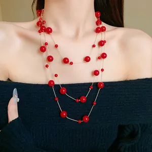 Vintage red faux pearl multi-layer necklace on black knit sweater for elegant style