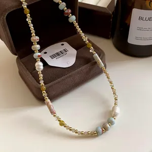 Vista dettagliata della collana con pietre multicolori e perle barocche naturali.