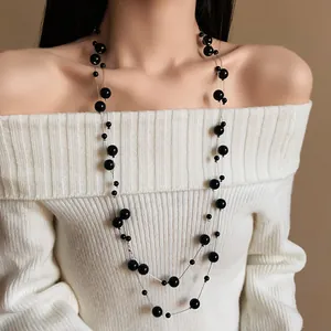 Elegant double-layered long necklace featuring black round beads on a silver chain.