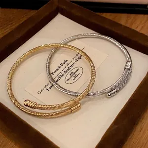 Set of gold and silver twisted cable cuff bracelets in a minimalist metallic design