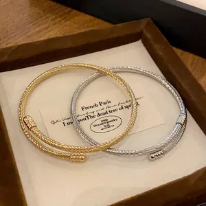 Macro view of gold and silver twisted metal cable bangles in a brown jewelry gift box