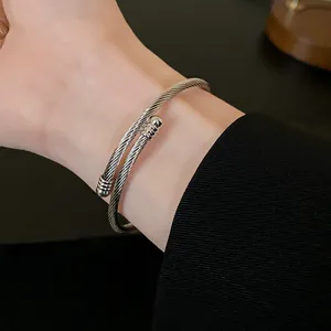Elegant silver twisted metal cuff bracelet with braided design worn on a human wrist