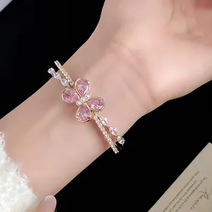 Vista detallada de una elegante pulsera de oro de doble capa con una mariposa de circón rosa