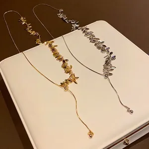 Elegant gold and silver wheat ear sequin tassel necklaces on a white display box