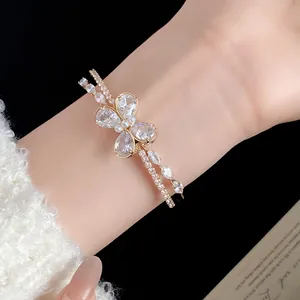 Primer plano detallado de un elegante brazalete abierto de doble capa con mariposa de circón