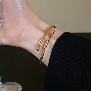 Close-up of elegant gold twisted cable cuff bracelet worn on wrist for aesthetic detail