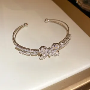 Primer plano de un brazalete abierto de mariposa de circonita con diseño de doble capa.