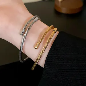 Close-up of minimalist metal twist braided cable bracelets in gold and silver finish