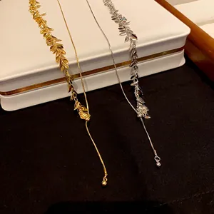Detail shot of elegant wheat spike sequin tassel necklaces in gold and silver metallic finishes