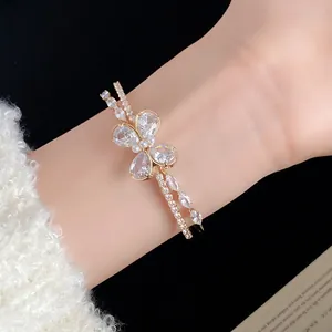 Detalle de un elegante brazalete de doble capa con una brillante mariposa de circonita.