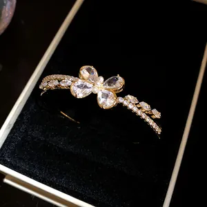 Detalle de una elegante pulsera de mariposa de circonita dorada en una caja de joyería negra