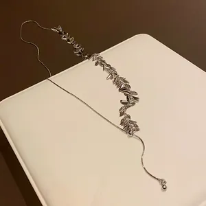 Close-up of elegant silver wheat sequin tassel necklace showing metallic texture