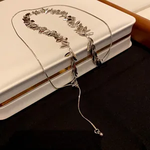 Macro view of a silver wheat ear sequin tassel necklace displayed on a jewelry box