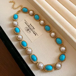 Detailed view of vintage French pearl necklace with turquoise stones in gold lace frame