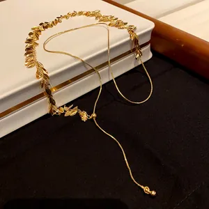 Detailed view of the gold wheat leaf sequins and adjustable tassel on the necklace chain