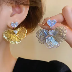 Close-up of elegant flower earrings with heart zircon and layered petals