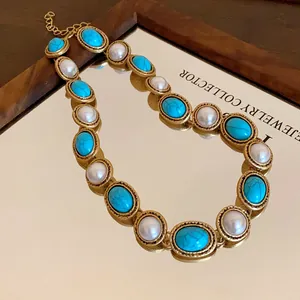 Close-up of vintage palace style necklace with faux pearls and turquoise stones