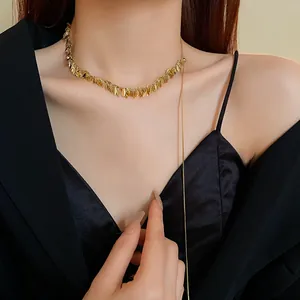 Detailed shot of a gold wheat-ear sequin necklace with a long tassel on a model.