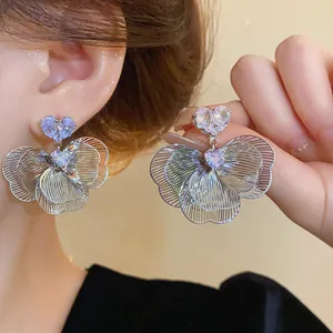 Detailed view of elegant silver flower stud earrings with heart-shaped zircon stones