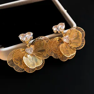 Detailed view of gold plated flower stud earrings with heart shaped cubic zirconia
