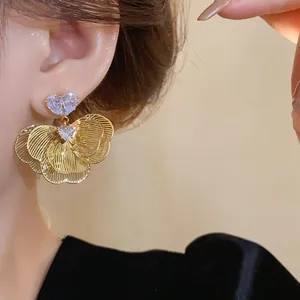 Detailed view of elegant gold-plated flower petal earrings with heart-shaped zircon studs
