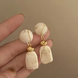Pendientes vintage franceses con textura de mármol, detalle de nudo dorado y aguja de plata