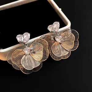 Detailed macro view of silver flower earrings with sparkling heart-shaped zircons