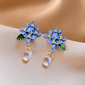 Vista dettagliata di orecchini a fiore blu stile foresta con perle a goccia iridescenti
