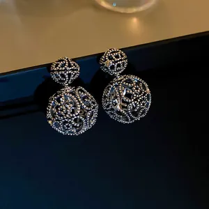 Elegant hollow silver metal double ball drop earrings with intricate lattice pattern