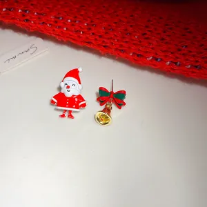 Detail view of asymmetric Christmas earrings with Santa Claus and golden bell bow
