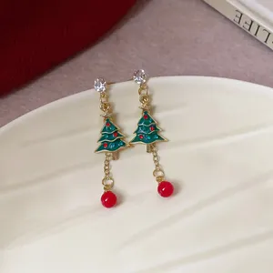 Exquisite macro detail of festive Christmas tree earrings with red beads and gems