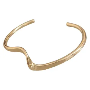 Elegant minimalist irregular pleated open cuff bracelet with a polished golden finish