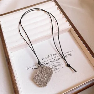 Elegant minimalist black leather cord necklace featuring a silver geometric mesh pendant