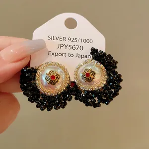 Detailed macro view of retro French style black crystal and pearl flower stud earrings