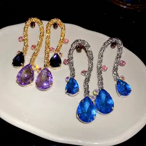 Vintage braided teardrop tassel earrings with sparkling rhinestones on ceramic plate