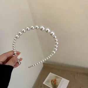 Detailed view of an elegant white pearl headband with beads in a gradient of sizes and luster