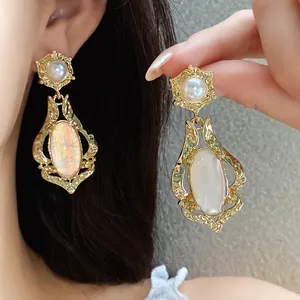 Close-up detail of vintage oval shell earrings with pearl studs and elegant golden frames