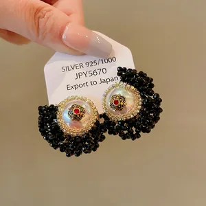A detailed close-up of vintage French style earrings with pearls and black crystals