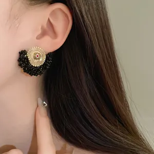 Close-up of vintage French style pearl and black crystal flower stud earring on ear