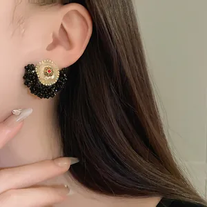Macro view of French vintage earring featuring black crystal beads and pearl flower