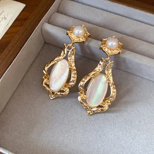 Vintage gold drop earrings with iridescent oval shell inlays and pearl studs detail shot.