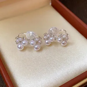 Elegant French-style bow clip-on earrings with pearls and zircons in a gift box.