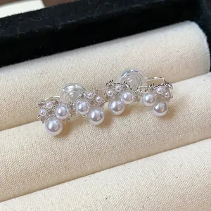Detail shot of elegant French bow clip-on earrings featuring white pearls and zircons