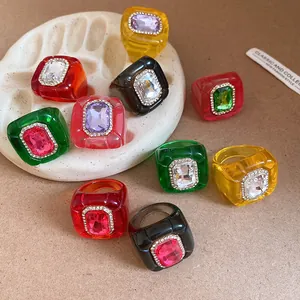 Close-up of colorful resin rings with rhinestone inlay and pleated texture
