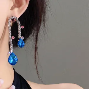 Detail of vintage braided earrings with vibrant blue pear-shaped teardrop crystals