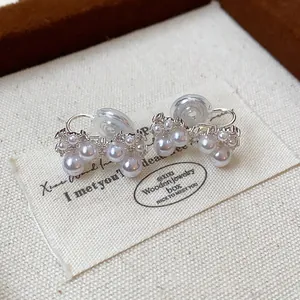 Detail shot of elegant silver bow clip-on earrings adorned with pearls and zircon