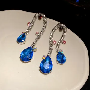 Detail showing twisted metal texture and blue teardrop crystals of the vintage earrings