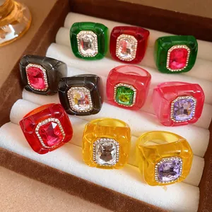 Detailed view of multiple colorful chunky resin rings with sparkling crystal center.