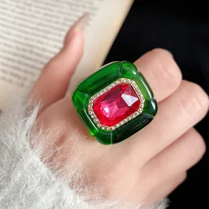 Detailed macro view of vintage green resin ring featuring a central red gemstone